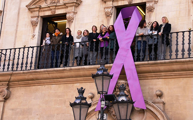 El Ayuntamiento de Palma cuelga un gran lazo morado en su fachada con motivo del Da Internacional de la Mujer | EUROPA PRESS